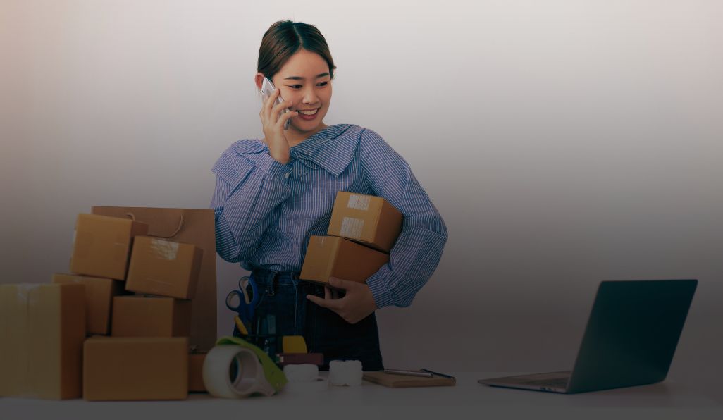 7-dicas-produtividade – Horaliv mulher no telefone segurando caixas